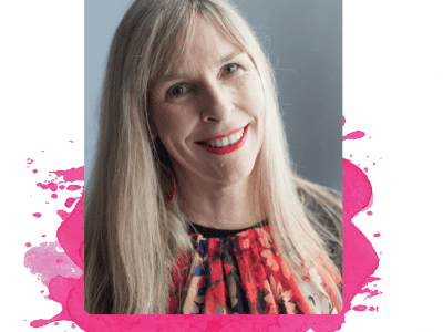 A blonde woman in a floral shirt smiles at the camera.