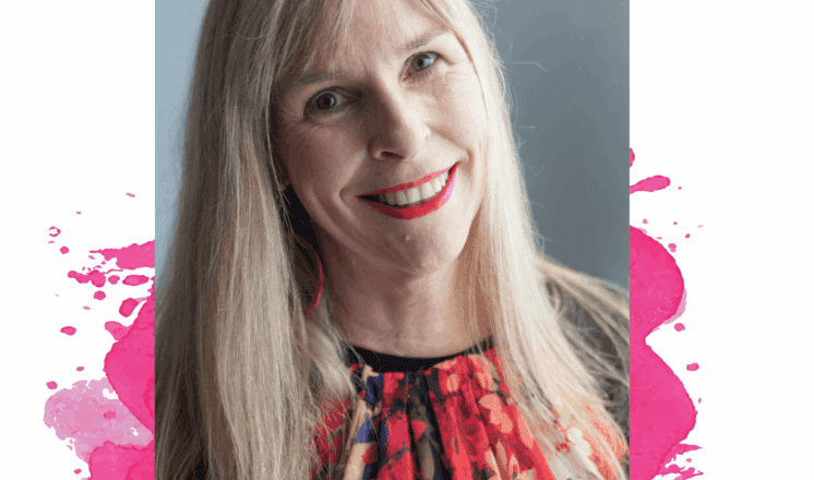 A blonde woman in a floral shirt smiles at the camera.